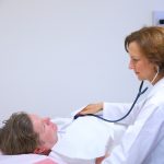 Doctor listening to patient's chest with stethoscope